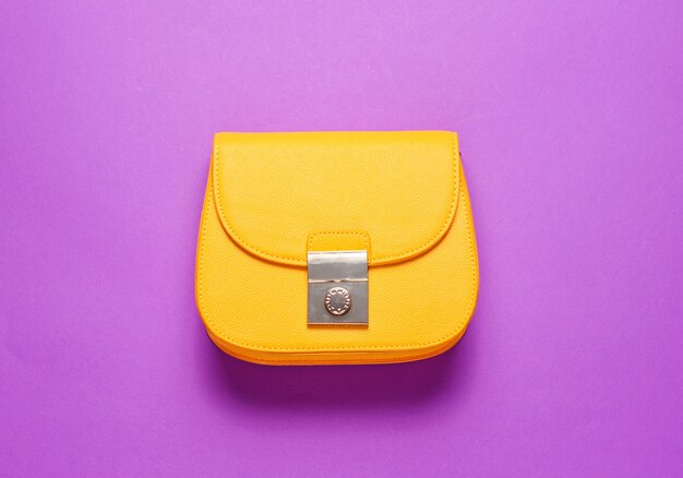 Yellow leather mini bag on blue surface