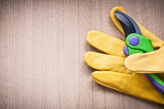 ヴィンテージボード農業コンセプトの剪定はさみと黄色の革の安全手袋