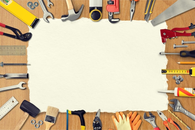 Photo yellow leather work gloves  and tools on background