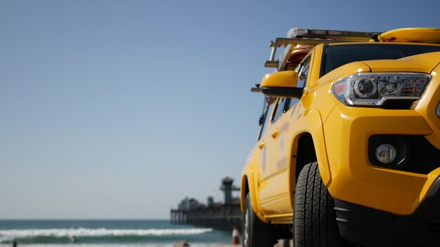 Yellow lifeguard car, Ocean beach, California USA. rescue life guard pick up truck vehicle. coast