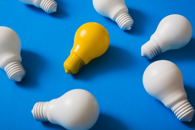 Foto lampadina gialla tra le lampadine bianche su sfondo blu