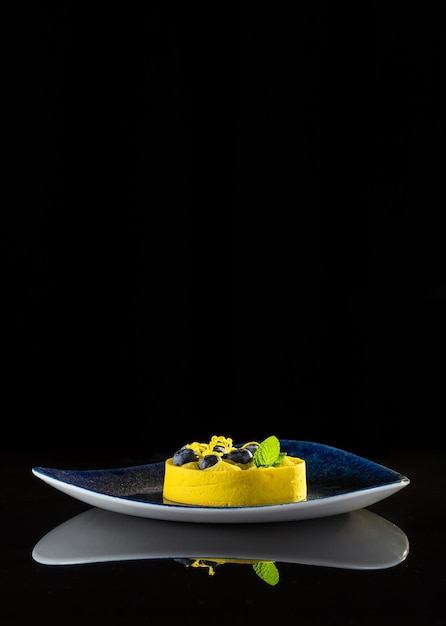 Yellow light dessert on a black background with reflection