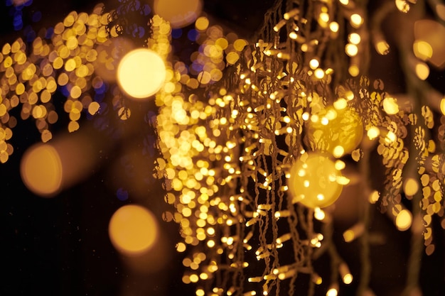 クリスマス ホリデー ガーランドから黄色のライトのボケ味がぼやけてお祭りの背景の抽象的なライト
