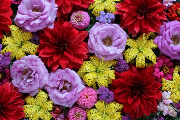 Yellow lilies, red dahlias and purple roses.