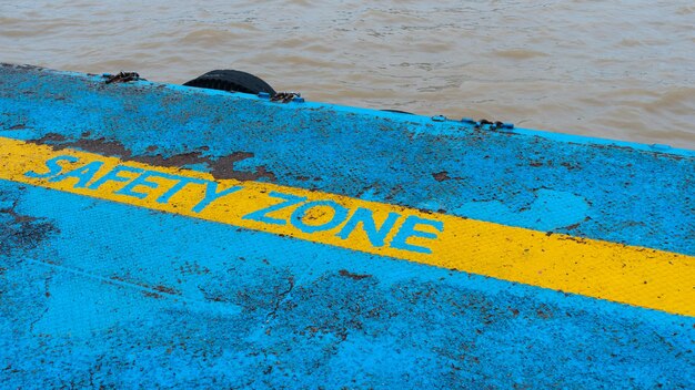 Yellow line safety zone on floor at watersideold rusted metal background iron pier with safety zone line rusty metal texture