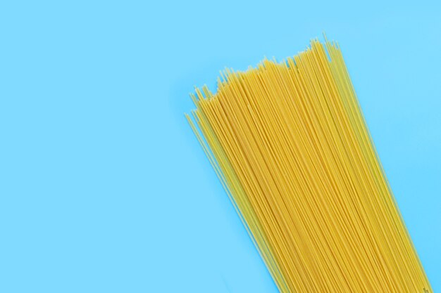 Photo yellow long spaghetti on blue surface