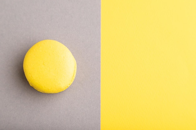 Yellow macaroon on trendy gray and yellow background top view copy space