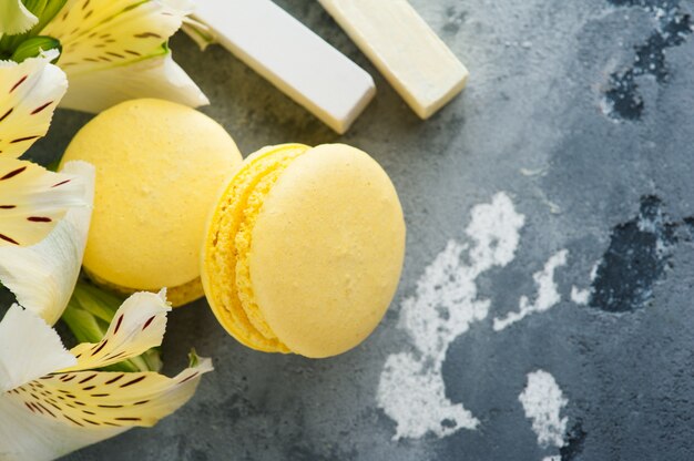 Yellow macaroons with flowers in background