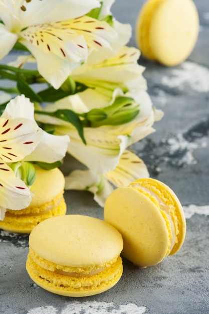 Yellow macaroons with flowers in background