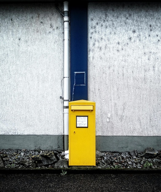 yellow mailbox against wall