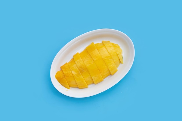 Yellow mango slices on blue background