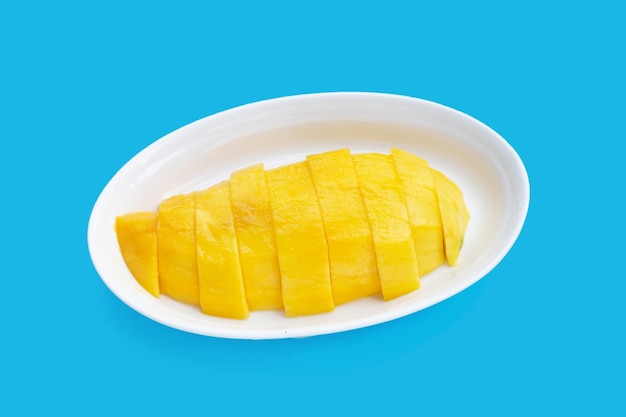 Yellow mango slices in plate blue background