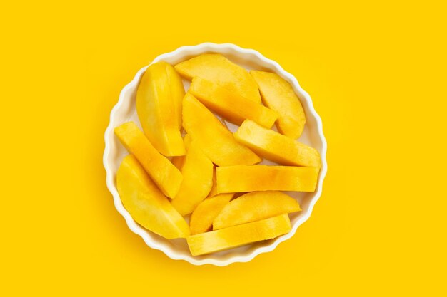 Yellow mango slices on yellow background