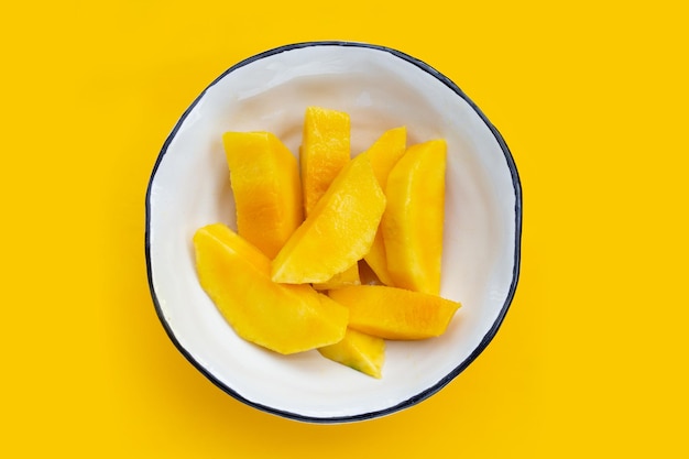 Yellow mango slices on yellow background