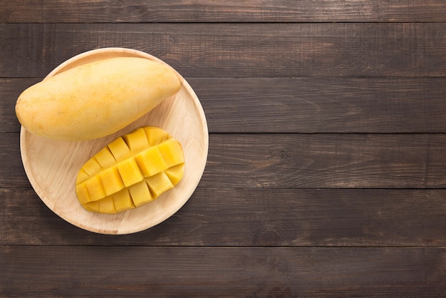 Yellow mangoes on a wooden background. Copy space for text