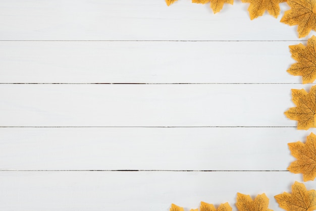 Yellow maple leaves on white wooden table