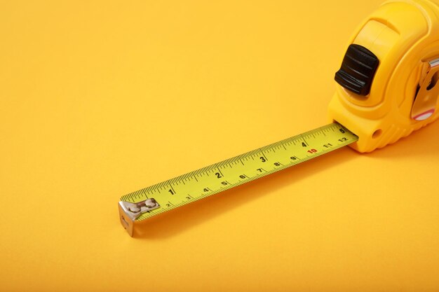 Photo the yellow measuring tape for the mason is placed on a yellow background soft focus