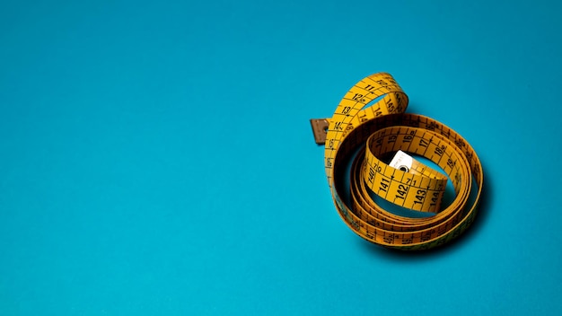 A yellow measuring tape sits on a blue background.