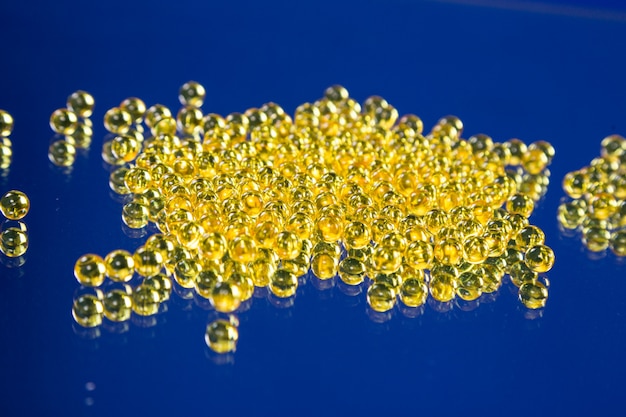 Yellow medical capsules on a mirror surface