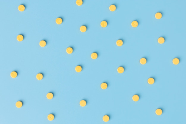 Yellow medical pills on blue background