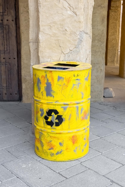 Yellow metal barrel with recycling symbol. container with sign.\
waste. disposal, utilization problem