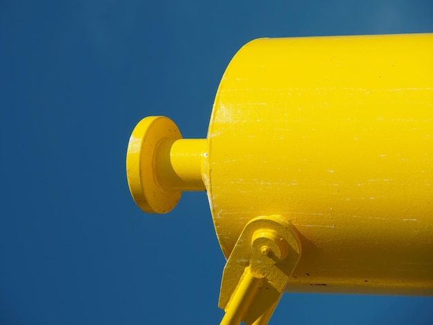 Photo yellow metal pipe against clear blue sky