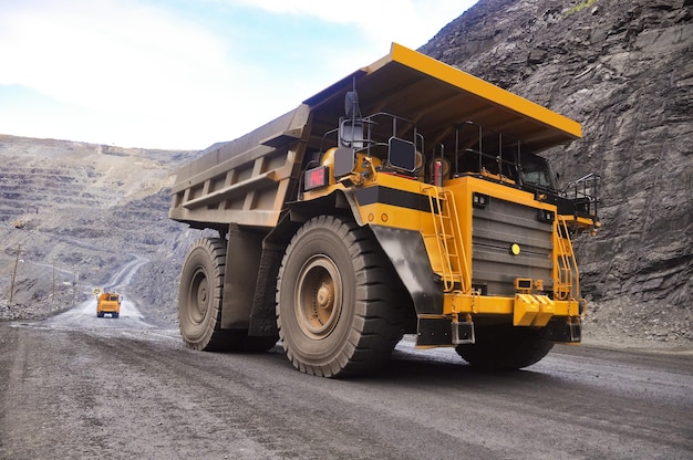 Photo a yellow mining truck transports rock and iron ore along the quarry