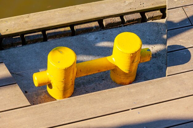 Yellow mooring post on deck by the sea background