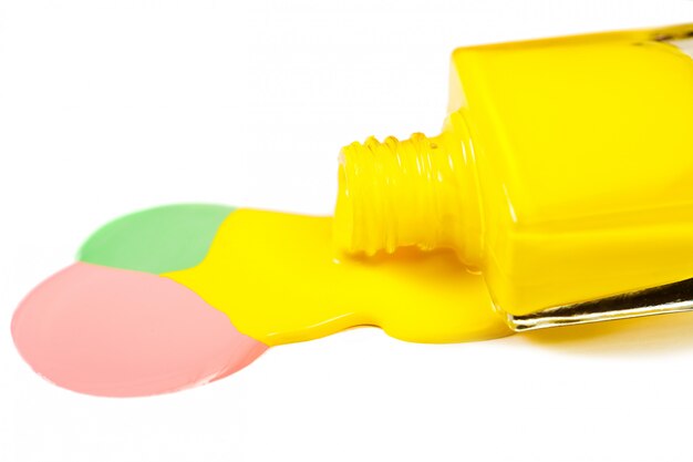 Yellow nail polish spilled isolated on white background