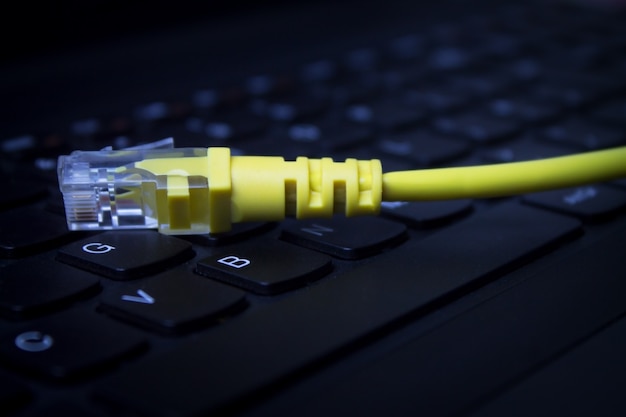 Yellow network cable on computer keyboard.