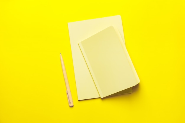 Yellow notebooks and pen on the Yellow background. Minimalism