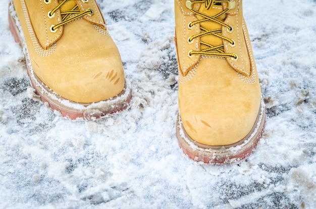 雪の中で黄色のヌバックブーツ