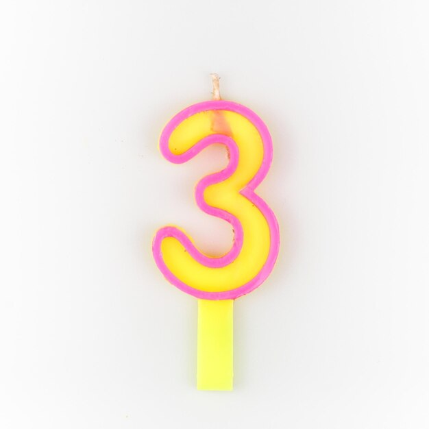 yellow number 3 candle isolated from white background