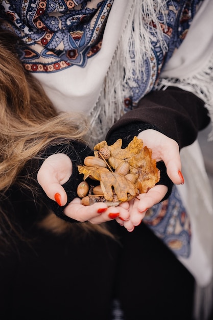 Yellow oak leaves in the hands of a girl