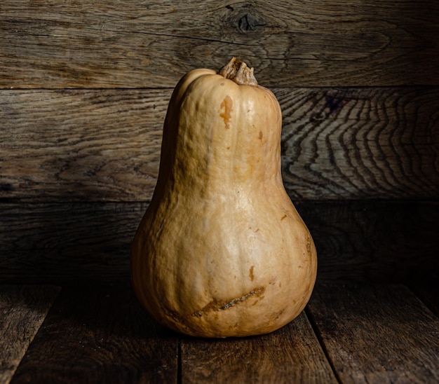 Yellow oblong pumpkin on the background of old wooden boards.