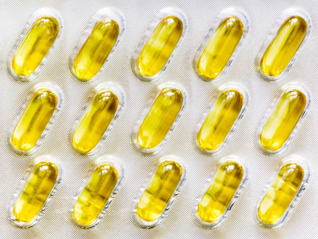 Photo yellow oil-filled soft gel capsule pills in the blister pack.