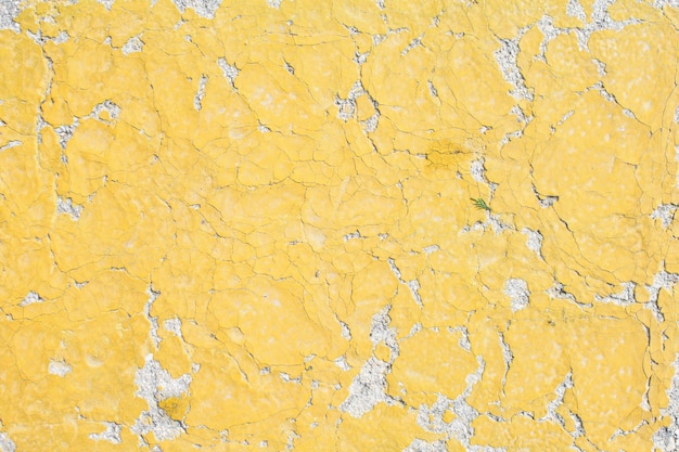 Photo yellow old cracked paint cracked by the heat in the sun on the concrete surface great for design and texture background