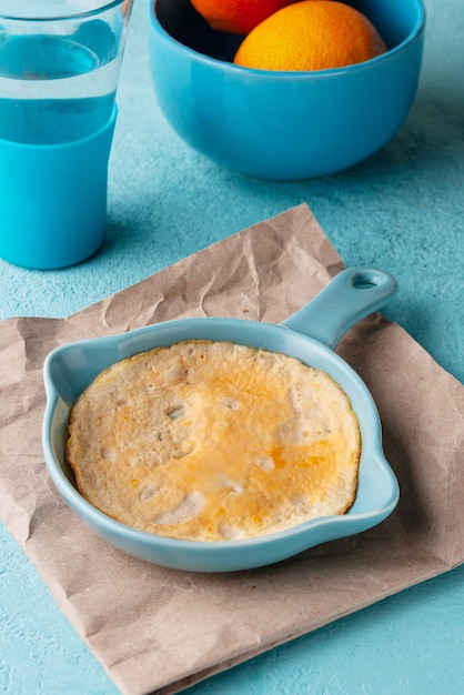 Photo yellow omelette in a blue frying pan on the table