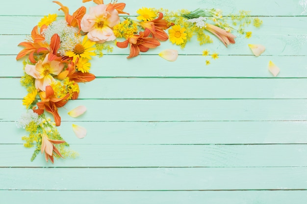 Yellow and orange flowers on green wooden