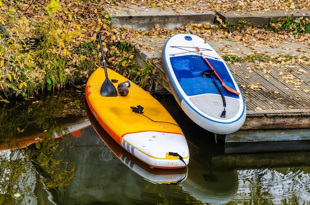 A yellow and orange kayak is next to a small boat.