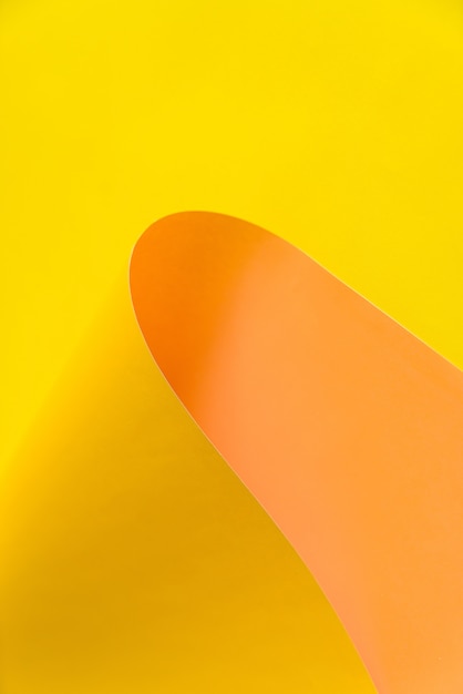 노란색과 오렌지색 종이 배경 추상 형태로 벤딩. 산이나 모래 언덕처럼 보입니다. 추상적 인 색 종이 배경.