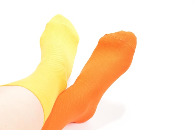 Yellow and orange socks on woman foot isolated on white background