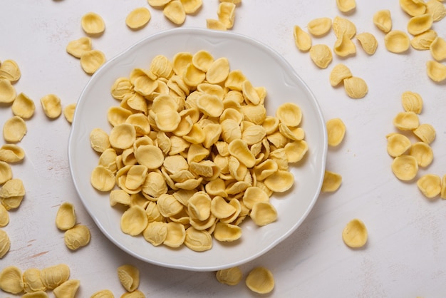 나무 테이블에 노란색 orecchiette 파스타