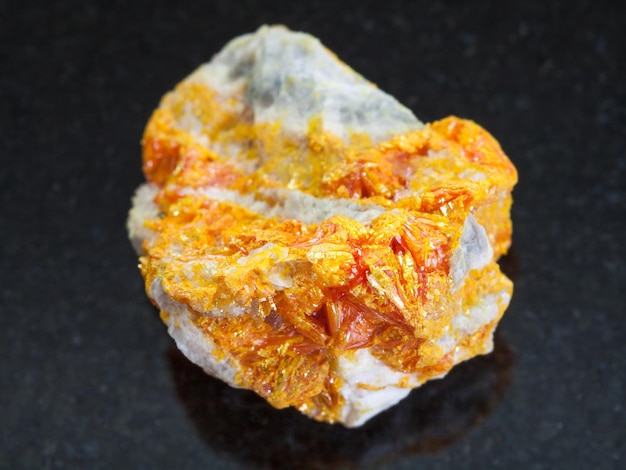 Yellow Orpiment crystals on dolomite stone on dark