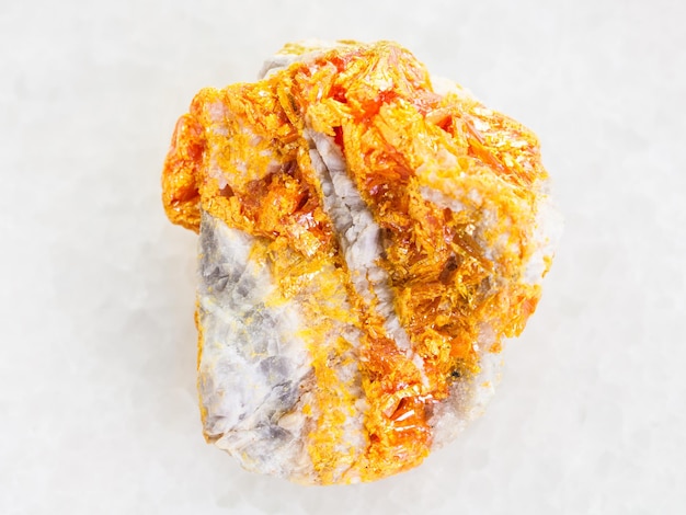 Yellow Orpiment on dolomite stone on white