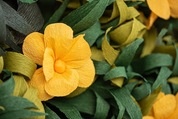 Yellow paper flowers among green leaves