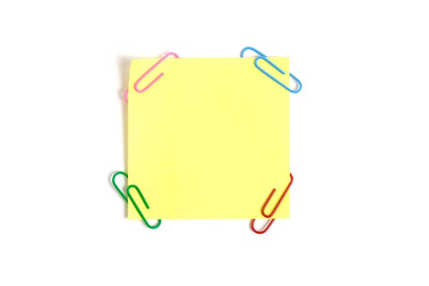 Yellow paper sticker for written notes and paper clips on a white background