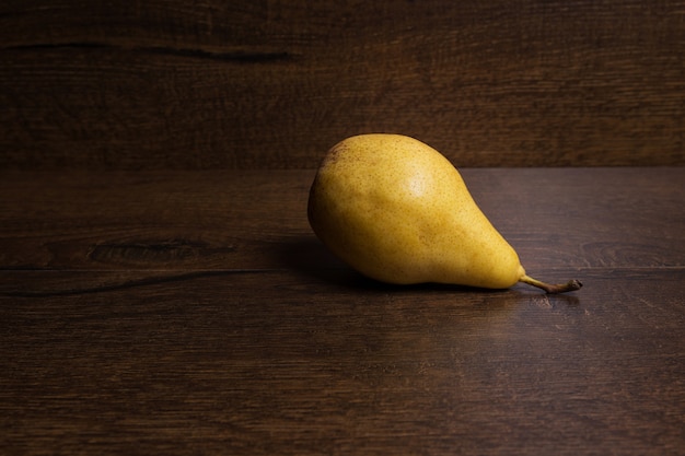 Yellow pear on a dark brown background