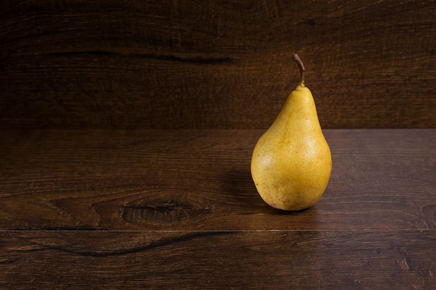 Yellow pear on a dark brown background