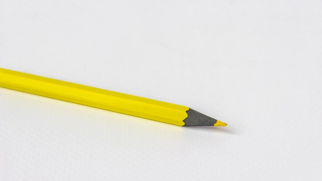 Желтый карандаш на белом фоне.